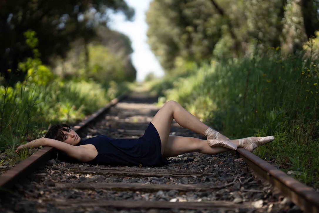 Outis distesa su un binario ferroviario, scarpette da punta